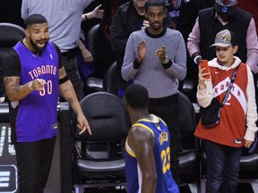 Rapper Drake, right, yells at Golden State Warriors forward Draymond Green (23) after the Toronto Raptors defeated the Warriors in Game 1 of the NBA championship basketball finals in Toronto on Thursday, May 30, 2019. THE CANADIAN PRESS/Nathan Denette