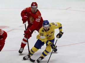 Sweden's William Nylander (right) is pursued by Russia's Mikhail Sergachyov during their world championship Group B match on Tuesday, Russia won 7-4. (Ronald Zak/The Associated Press)
