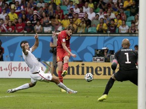 United States' Omar Gonzalez tries to defend as Belgium's Jan Vertonghen gets a shot on United States' goalkeeper Tim Howard during the World Cup round of 16 soccer match between Belgium and the USA at the Arena Fonte Nova in Salvador, Brazil, Tuesday, July 1, 2014. (AP Photo/Marcio Jose Sanchez)