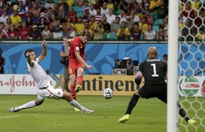United States' Omar Gonzalez tries to defend as Belgium's Jan Vertonghen gets a shot on United States' goalkeeper Tim Howard during the World Cup round of 16 soccer match between Belgium and the USA at the Arena Fonte Nova in Salvador, Brazil, Tuesday, July 1, 2014. (AP Photo/Marcio Jose Sanchez)