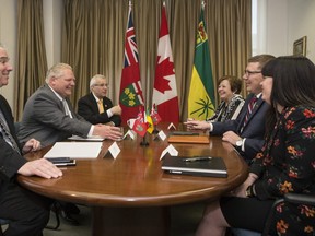 Ontario Premier Doug Ford, second left, is joined by Chief of Staff Dean French, left, and Ontario Finance Minister Vic Fedeli as they meet with Saskatchewan Premier Scott Moe, second right, Saskatchewan Finance Minister Donna Harpauer, third right, and Chief of Staff Shannon Andrews, right, in Toronto, on Friday, May 10, 2019. THE CANADIAN PRESS/Chris Young