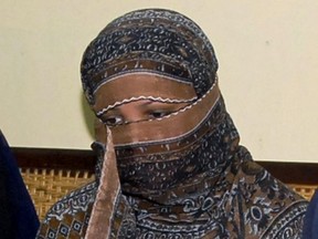 In this Nov. 20, 2010, file photo, Aasia Bibi, a Pakistani Christian woman, listens to officials at a prison in Sheikhupura near Lahore, Pakistan. Pakistani media say Aasia Bibi, a Christian woman acquitted of blasphemy after spending eight years on death row, has left Pakistan for Canada to be reunited with her daughters.