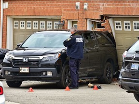 Peel Regional Police  forensics officers collect evidence at the scene of an alleged impaired driving crash that seriously injured a young boy and his mother.