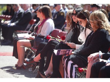 Members of the Fallen Families group sit at the front of the ceremony with roses at the 20th annual Ontario Police Memorial Foundation ceremony held at Queens Park honours the 266 officers who have fallen in the line of duty over the years on Sunday May 5, 2019. Jack Boland/Toronto Sun/Postmedia Network