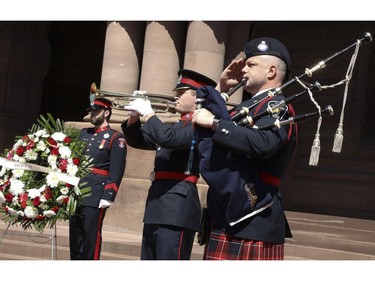 Jordan Mackintosh of the London Police Service and preforms the Last Post as bagpiper Michael Giles of York Regional Police Service awaits to play the Lament at the 20th annual Ontario Police Memorial Foundation ceremony held at Queens Park honours the 266 officers who have fallen in the line of duty over the years on Sunday May 5, 2019. Jack Boland/Toronto Sun/Postmedia Network