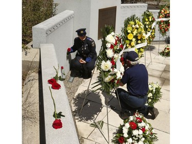 A paramedic poses for a photo after finding a relative on the memorial wall after the 20th annual Ontario Police Memorial Foundation ceremony held at Queens Park honours the 266 officers who have fallen in the line of duty over the years on Sunday May 5, 2019. Jack Boland/Toronto Sun/Postmedia Network