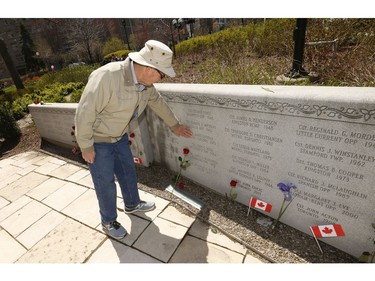 A former Metrot Toronto officers touches a former friend on the memorial wall after the 20th annual Ontario Police Memorial Foundation ceremony held at Queens Park honours the 266 officers who have fallen in the line of duty over the years on Sunday May 5, 2019. Jack Boland/Toronto Sun/Postmedia Network