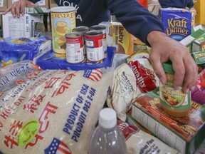 Volunteers sort food at the Daily Bread Food Bank in Toronto, Ont. on Saturday October 11, 2014.