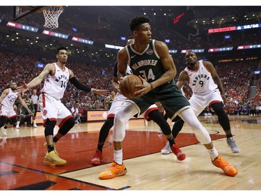 Milwaukee Bucks Giannis Antetokounmpo PF (34) is triple teamed by Toronto Raptors Serge Ibaka C (9) and teammate Danny Green SG (14) during first quarter in Toronto, Ont. on Sunday May 19, 2019. Jack Boland/Toronto Sun/Postmedia Network