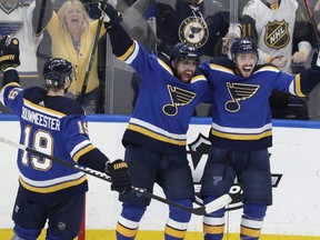 St. Louis Blues' Jay Bouwmeester (19), David Perron (57) and Tyler Bozak (21) celebrate after Bozak scored a goal against the San Jose Sharks during the third period in Game 6 of the NHL hockey Stanley Cup Western Conference final series Tuesday, May 21, 2019, in St. Louis. The Blues won 5-1 to win the series 4-2. (AP Photo/Tom Gannam)