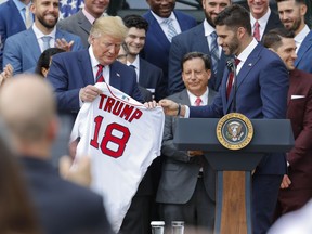 Outfielder J.D. Martinez, right, presents a team jersey to President Donald Trump, left, during a ceremony on the South Lawn of the White House in Washington, Thursday, May 9, 2019, where Trump honored the 2018 World Series Baseball Champion Boston Red Sox.