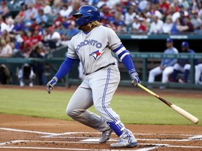 Blue Jays' Vladimir Guerrero Jr. follows through on an RBI single off Rangers starting pitcher Lance Lynn during first inning MLB action in Arlington, Texas, Saturday, May 4, 2019.