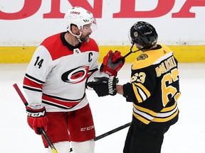 Justin Williams of the Carolina Hurricanes pulls on the chinstrap of Brad Marchand of the Boston Bruins during the second period in Game 2 of the Eastern Conference Final during the 2019 NHL Stanley Cup Playoffs at TD Garden on May 12, 2019 in Boston.