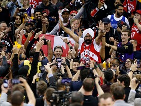 Toronto Raptors fans celebrate during their team's win against the Warriors in Oakland on Friday. (GETTY IMAGES)