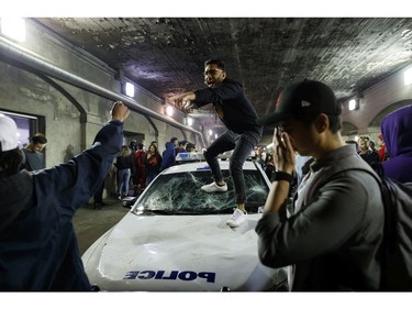 People stand on a Police cruiser as they celebrate a victory over the Golden State Warriors in game six of the NBA Finals on June 13, 2019 in Toronto.
