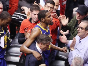 TORONTO, ONTARIO - JUNE 10:  Kevin Durant #35 of the Golden State Warriors is assisted off the court after sustaining an injury in the first half against the Toronto Raptors during Game Five of the 2019 NBA Finals at Scotiabank Arena on June 10, 2019 in Toronto, Canada. NOTE TO USER: User expressly acknowledges and agrees that, by downloading and or using this photograph, User is consenting to the terms and conditions of the Getty Images License Agreement. (Photo by Claus Andersen/Getty Images)