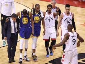 Kyle Lowry #7 of the Toronto Raptors reacts as Kevin Durant #35 of the Golden State Warriors is helped off the court in the first half during Game Five of the 2019 NBA Finals at Scotiabank Arena on June 10, 2019 in Toronto (Photo by Claus Andersen/Getty Images)