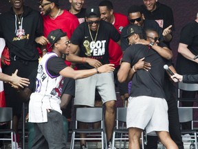 Toronto Raptors embrace on a stage at Nathan Phillips Square during Monday's victory parade and celebration. (Stan Behal, Toronto Sun)