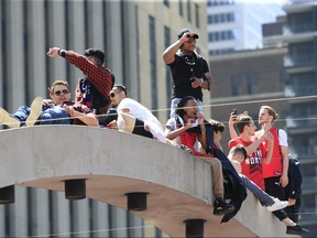 Toronto Raptors fans climbed the arches at Toronto's Nathan Phillips Square during the Toronto Raptors celebration parade in Toronto, June 17, 2019. (Stan Behal/Toronto Sun/Postmedia Network)