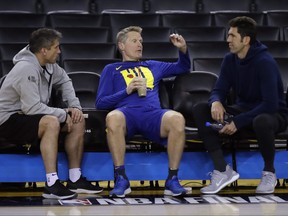 Warriors coach Steve Kerr talks to Dr. Rick Celebrini (left), the team’s director of sports medicine and performance, and GM Bob Myers (right) during yesterday’s practice at Oracle Arena.  Ben Margot/AP