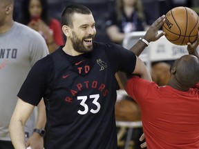 Raptors centre Marc Gasol (left) smiles next to a team assistant during a practice in Oakland yesterday.  The Associated Press