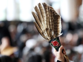 A woman holds an eagle feathers during the closing ceremony of the National Inquiry into Missing and Murdered Indigenous Women and Girls in Gatineau, Quebec, Canada, June 3, 2019. REUTERS/Chris Wattie ORG XMIT: GGG-CJW18