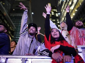 In this file photo taken on June 10, 2019 Toronto Raptor fans cheer during a street party in Jurassic Park, outside of Scotiabank Arena in Toronto, Ontario, during Game 5 of the NBA Championships against the Golden State Warriors. -