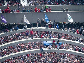 Fans climb the arches at Nathan Phillips Square ahead of the 2019 Toronto Raptors Championship parade in Toronto, on Monday, June 17, 2019. THE CANADIAN PRESS/Andrew Lahodynskyj