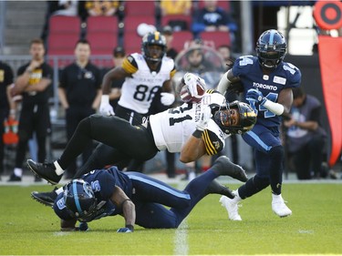 Hamilton Tiger Cats Sean Thomas Erlington RB (31) goes over a diving Toronto Argonauts Jermaine Gabriel DB (5) for yardage over during the second quarter in Toronto, Ont. on Saturday June 22, 2019. Jack Boland/Toronto Sun/Postmedia Network