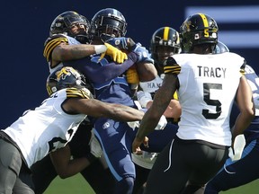 Argos wide receiver S.J. Green gets gang-tackled by the Tiger-Cats defence during yesterday’s game at BMO Field. The Argos had no answer for the Tabbies on offence, defence or special teams in a 64-14 season-opening loss.  Jack Boland/Toronto Sun