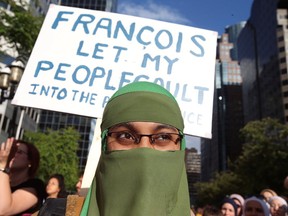 People protest Quebec's new Bill 21, which will ban teachers, police, government lawyers and others in positions of authority from wearing religious symbols such as Muslim head coverings and Sikh turbans, in Montreal, Quebec, Canada, June 17, 2019. (REUTERS/Christinne Muschi)