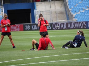 Canada players Shelina Zadorsky, left, Allysha Chapman, centre, Christine Sinclair, and Stephanie Labbe relax on the field at the Stade de le Mosson in Montpellier, France on Sunday June 9, 2019. Canada play Cameroon on Monday in its opening game of the 2019 FIFA Women's World Cup.