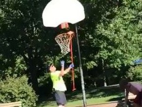 A City of Toronto worker removes a basketball net from a park in a video posted to Twitter.