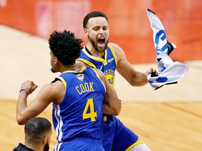 Golden State Warriors guard Quinn Cook (left) and teammate Stephen Curry celebrate Cook’s three-point shot that finished the Raptors during Game 2 at Scotiabank Arena on Sunday night. The series heads to Oracle Arena in Oakland. (USA TODAY)