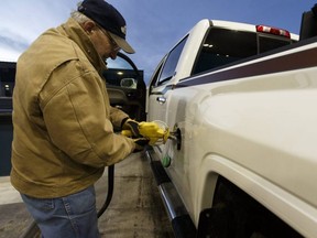 Ron Noble fills up his truck and his auxiliary tank at a Co-op Cardlock station in Lloydminster, Alta., on Dec. 22, 2016.