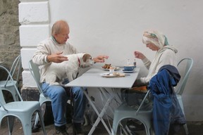 Bristol residents Colin Green and Michele Coss enjoy lunch on patio of Anna Cake Couture bakery and tea shop, with Parson Russell dogs — ‘Bandit” in his lap, ‘Tedda’ under the table. (Ian Robertson)