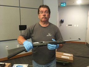 Toronto Police Acting Senior Firearms officer Bruce Finn holds up a long gun, one of the many firearms seized in Project Kraken, during a news conference at headquarters on Friday, June 28, 2019. (Joe Warmington/Toronto Sun/Postmedia Network)