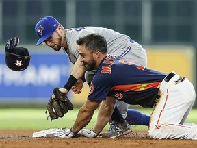 Jack Mayfield of the Houston Astros doubles in the sixth inning as he loses his helmet as Eric Sogard of the Toronto Blue Jays applies the tag at Minute Maid Park on June 15, 2019 in Houston, Texas. (Bob Levey/Getty Images)