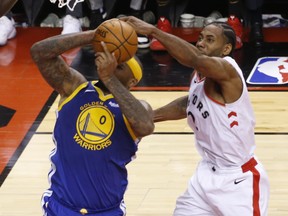 Raptors star Kawhi Leonard (right2) gets his hand on the ball as the Golden State Warriors' DeMarcus Cousins goes to the basket. (Jack Boland/Toronto Sun)