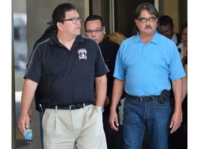 Scott Altiman, centre, hides behind a group of supporters as he leaves the London Courthouse after pleading guilty to two counts of impaired driving causing death and several other charges on Thursday June 8, 2017.