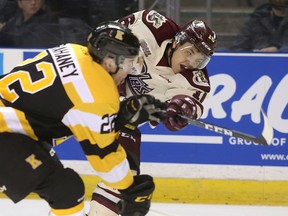 Peterborough Petes Nick Robertson, right,  gets a shot off past Kingston Frontenacs defenceman Jakob Brahaney during Ontario Hockey League action at the Leon's Centre in Kingston on Friday Jan. 4, 2019. (Ian MacAlpine/The Whig-Standard/Postmedia Network)