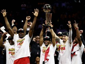 Kawhi Leonard, centre, of the Toronto Raptors celebrates with the Larry O'Brien Championship Trophy after his team defeated the Golden State Warriors to win Game Six of the 2019 NBA Finals at ORACLE Arena on June 13, 2019 in Oakland, Calif.