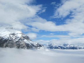 Peaks of distant mountains, seen from the Cliffside Bistro on Mount Norquay near Banff, Alta., appear to float on a sea of cloud. (Ken Winlaw)