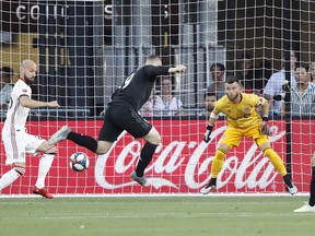 D.C. United forward Wayne Rooney  deflects the ball toward goal as Toronto FC goalkeeper Quentin Westberg prepares to make a save at Audi Field. (USA TODAY)