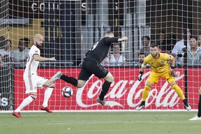 D.C. United forward Wayne Rooney  deflects the ball toward goal as Toronto FC goalkeeper Quentin Westberg prepares to make a save at Audi Field. (USA TODAY)