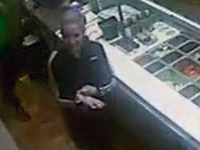 A still photo taken from security camera footage showing the sandwich thief behind the counter of the sandwich shop.