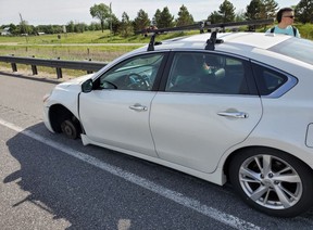 A car that lost its wheel on Hwy. 400 is seen on June 12, 2019. (OPP_HSD/Twitter)