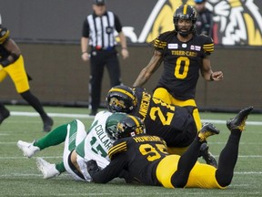 Roughriders quarterback Zach Collaros is hit late by Tiger-Cats' Simoni Lawrence after Collaros was downed by Tiger-Cats' Julian Howsare during first half CFL action in Hamilton on June 13, 2019.