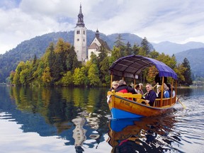 Visitors enjoy a scenic ride to a Lake Bled island on a traditional pletna boat. (Cameron Hewitt)