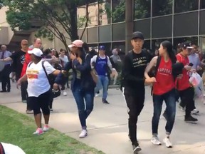 People flee Nathan Phillips Square after shots ring out during Monday's Raptors celebration rally